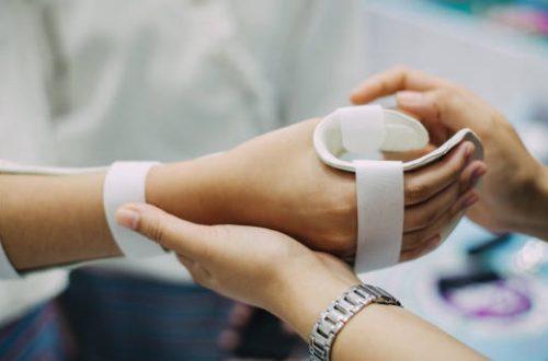 Hand occupational therapist making assistive device for immobilize patient hand. Splint service for hand injury rehabilitation of occupational therapy clinic.